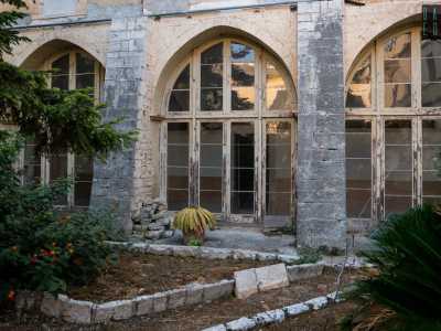 La luce nel corridoio proviene da grandi finestroni a mandorla che si aprono su uno dei tre chiostri interni che appartenevano al precedente monastero